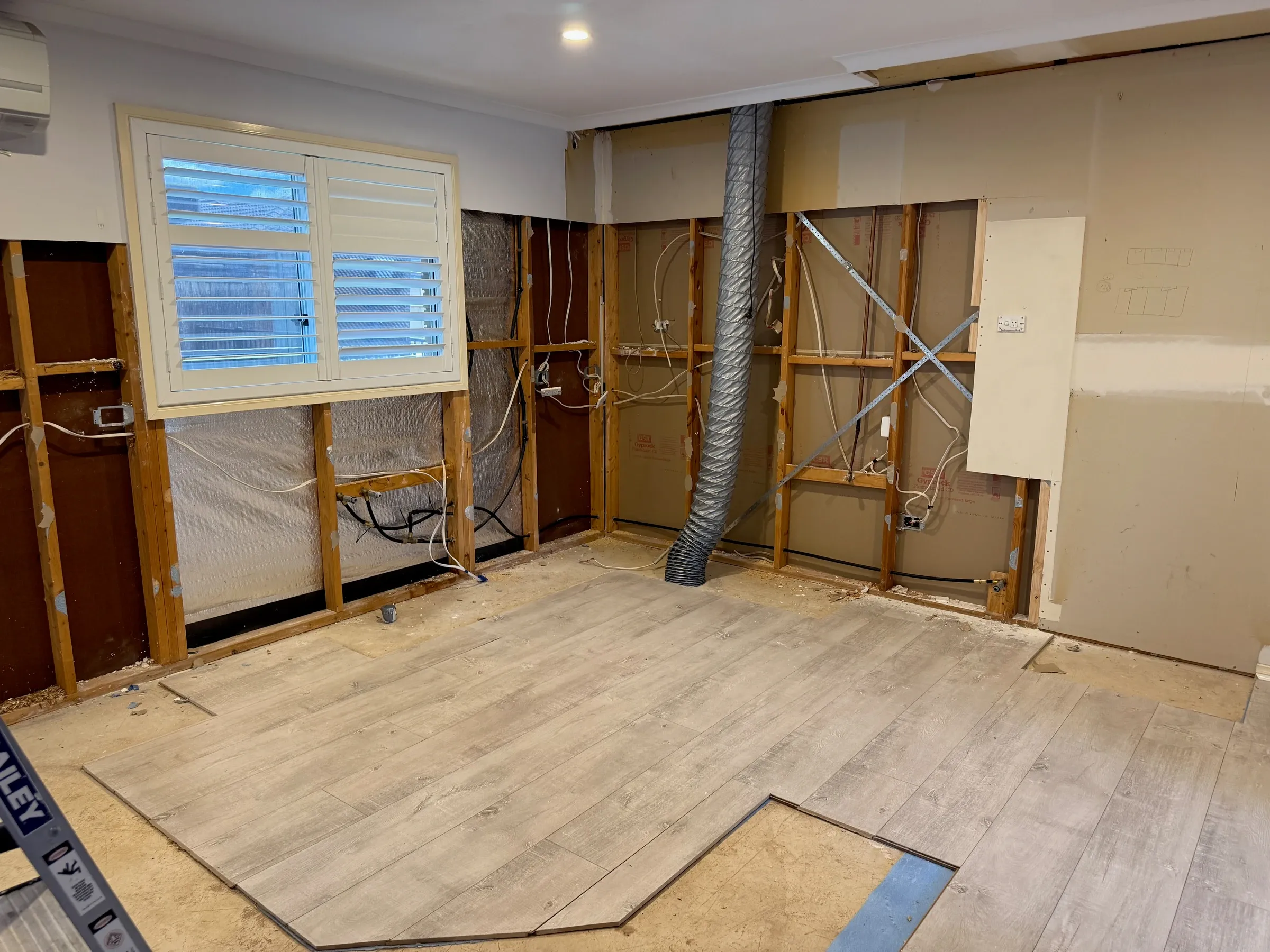Kitchen during strip-out with walls and services exposed