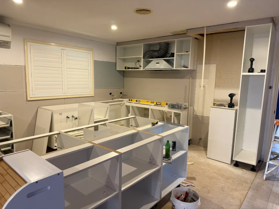 Bluestone kitchen during installation, showing cabinet carcasses and the unfinished island
