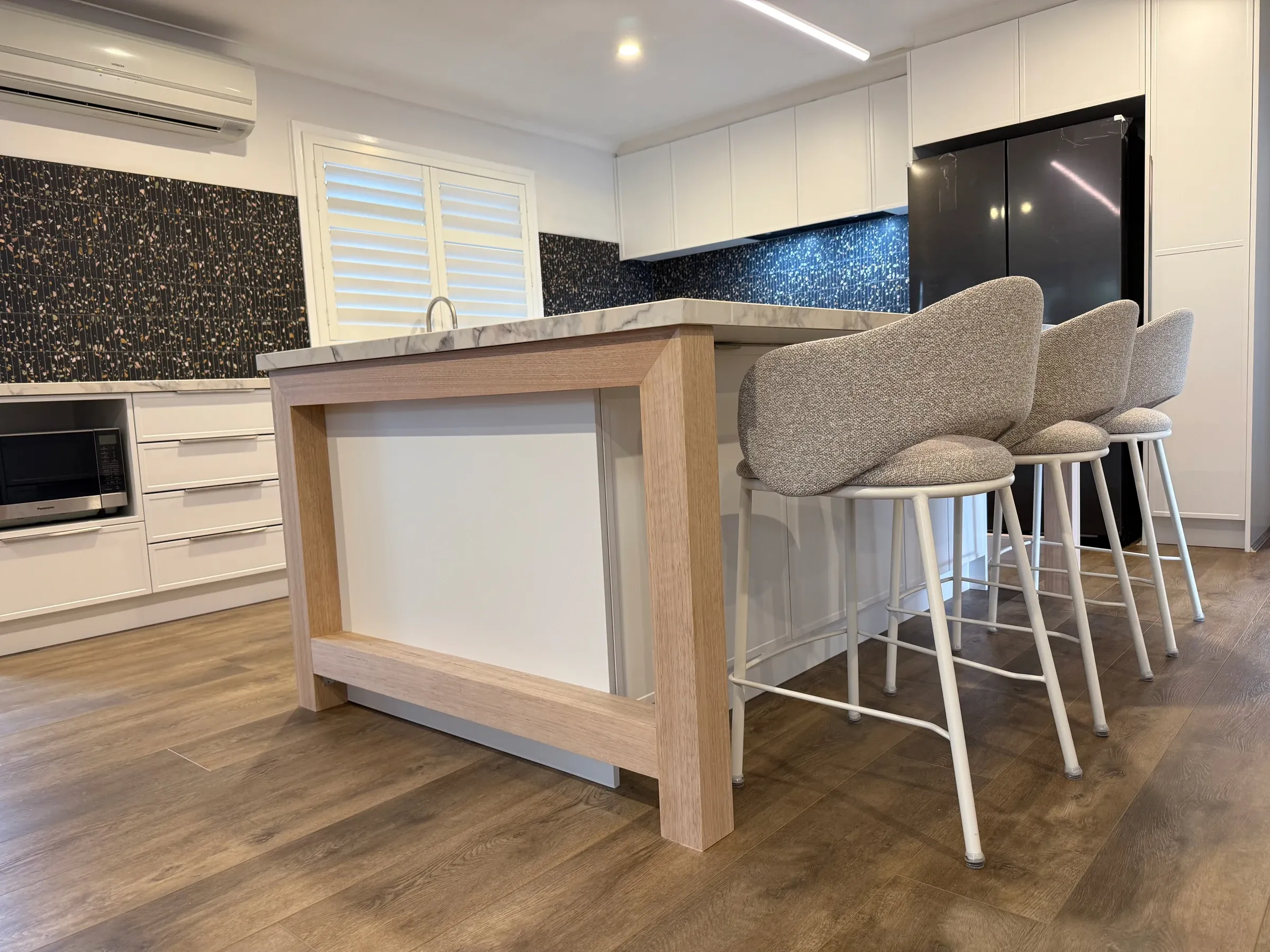 Three seats at the completed Bluestone kitchen island